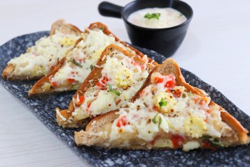 Chili Cheese toast, Open cheese sandwich or mini bread pizzas served with mayonnaise deep and garnished with chopped Basil leaves.