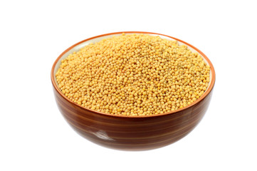 yellow mustard seeds in bowl isolated on white background