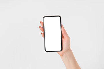 Female hand holding and touching on mobile smartphone with white screen. Isolated on white. Photo template for any images on mobile phone display Layout with easily removable phone monitor background