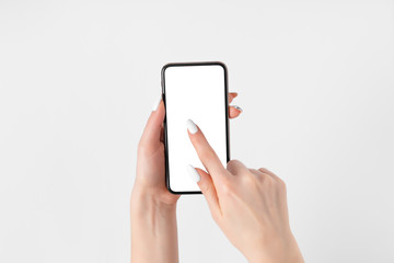 Female hand holding and touching on mobile smartphone with white screen. Isolated on white. Photo template for any images on mobile phone display Layout with easily removable phone monitor background