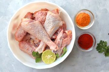 Clean and Raw Free range or country chicken carved in parts in a bowl with Indian spices and cooking ingredients. Along with copy space