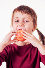 Close up portrait of a serious child girl with apple as symbol of diet and healthy food. Vertical image.