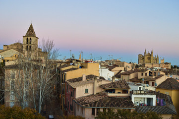 Fototapeta na wymiar Palma de Mallorca rooftops and architecture with cathedral in the back during sunset, Spain