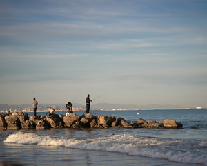 Men fishing in the rocks II