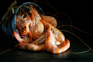 Fresh shrimps in the bucket on the wooden natural background. © GalaDesign
