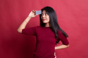Young Asian woman think with a blank card.