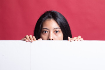 Close up of young Asian woman behind a blank sign.