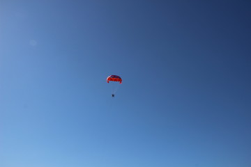 Fototapeta na wymiar paragliding in the blue sky with colorful parachute