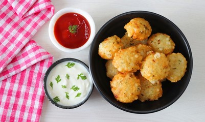 Sabudana vada or Sago fried fitters served with Curd or yogurt and ketchup over white wooden background, popular fasting recipe from India or mostly eaten during Fasting