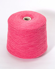 Green bobbin of yarn on a white background.Textile reel on isolated white background.