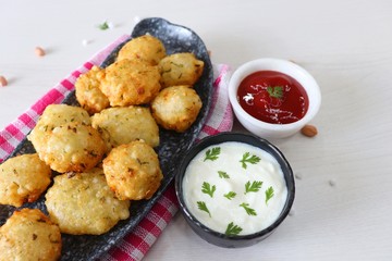 Sabudana vada or Sago fried fitters served with Curd or yogurt and ketchup over white wooden background, popular fasting recipe from India or mostly eaten during Fasting