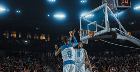 Basketball players on big professional arena during the game. Tense moment of the game. Celebration