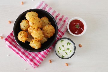 Sabudana vada or Sago fried fitters served with Curd or yogurt and ketchup over white wooden background, popular fasting recipe from India or mostly eaten during Fasting