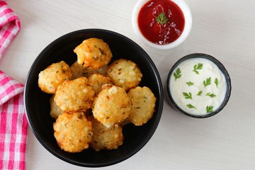 Sabudana vada or Sago fried fitters served with Curd or yogurt and ketchup over white wooden background, popular fasting recipe from India or mostly eaten during Fasting