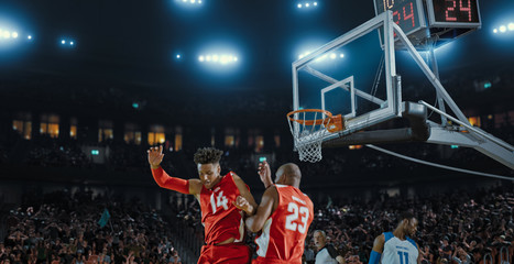 Basketball players on big professional arena during the game. Tense moment of the game. Celebration