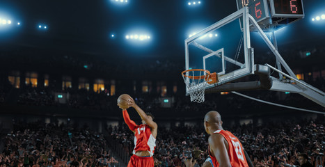 Basketball players on big professional arena during the game. Tense moment of the game. Celebration