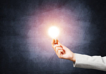 Woman hand with glowing incandescent lamp