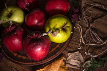 Fresh autumn apples on rural wooden background, natural rough fruit surface