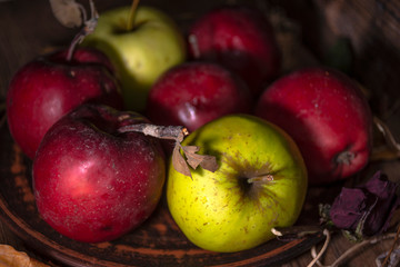 Fresh autumn apples on rural wooden background, natural rough fruit surface