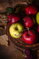 Fresh autumn apples on rural wooden background, natural rough fruit surface