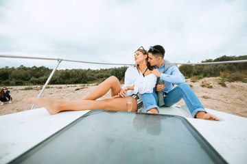 Romantic couple in love on sail boat at under sunlight on yacht. Happy exclusive alternative lifestyle concept. Love story of two lovers. Two young tourists having fun on boat tour in the summertime