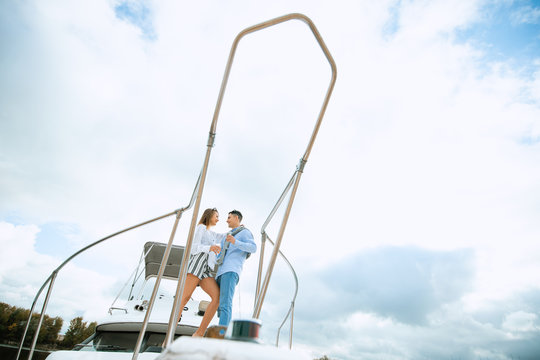 Newlyweds in love on sail boat with champagne - Happy exclusive alternative lifestyle concept. Couple celebrating with champagne on a boat having party with girlfriend on vacation.