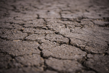 Dark asphalt road with cracks. Background texture,Cracks in the asphalt road.