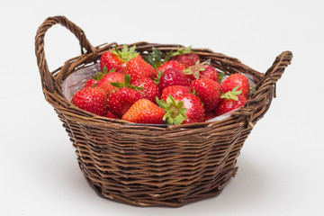 Fototapeta na wymiar Fresh juicy strawberries in basket. Wicker basket full of freshly picked strawberries