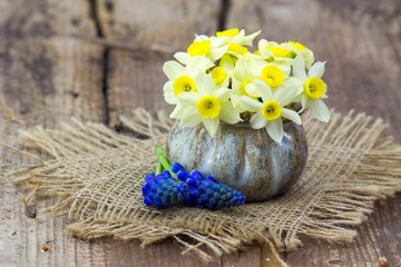 spring flowers bouquet in a vase on wooden background