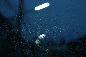 water rain drop on glass window with blur street light in night town background - Powered by Adobe