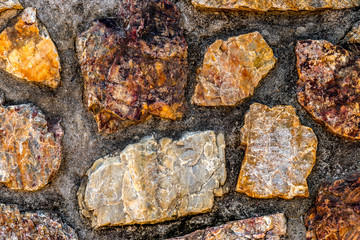 A closeup of a stonewall held together by mortar