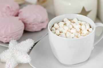 Fototapeta na wymiar White сup of coffee with marshmallows on the background of sweets and Christmas decor