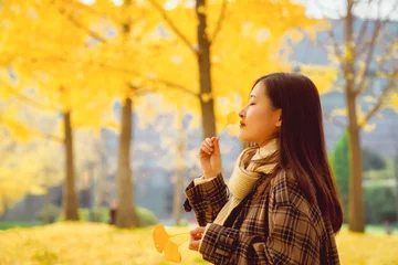 Fotobehang Oranje Autumn, girls and yellow gingko leaves  © 云 王