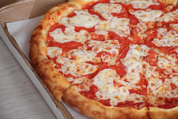 Close-up of a juicy Margarita pizza in a box. Food delivery.