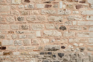wall of the historical building is made of different stones. Texture.