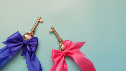 A pair of keys with blue and pink ribbon tied onto the keys. Copy space on the top right corner.