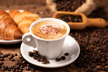 A cup of cappuccino with coffee bean as background. - 311876981