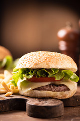 fresh tasty burger and french fries on wooden table