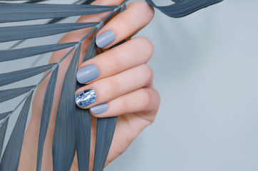Beautiful female hand with blue nail design - obrazy, fototapety, plakaty