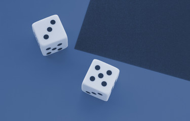 Dice on a blue and yellow background, toned trendy classic blue color of year 2020