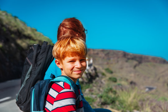 father and son travel on road in mountains