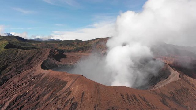 Aerial shot of smoking Mount Bromo, full crater shot, horizon view, slightly rotating. Java, Indonesia