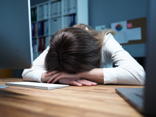 Tired female employee at office workplace taking nap