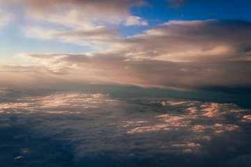 Naklejka na ściany i meble Sunset above the clouds landscape from an airplane journey