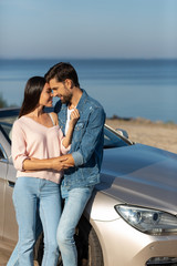 Fototapeta premium attractive woman and handsome man in love embracing at the background at daytime, portrait