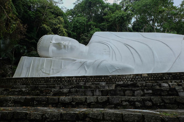  The largest statue of a reclining Buddha in Vietnam. White color. Mount Ta ku, Vietnam.The length of the statue is 49 m.