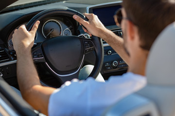 back view of caucasian man driving cabriolet