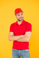 Postman delivery worker. Man red cap yellow background. Delivering purchase. Always on time. Dedicated to your business. Service delivery. Salesman and courier career. Courier and delivery service