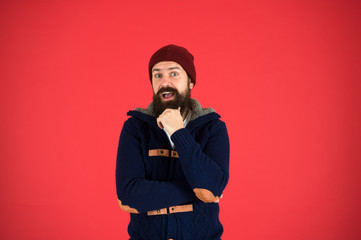 Think and decide. Winter menswear. Man bearded warm jumper and hat red background. Winter season menswear. Personal stylist. Warm and comfortable. Fashion menswear shop. Masculine clothes concept