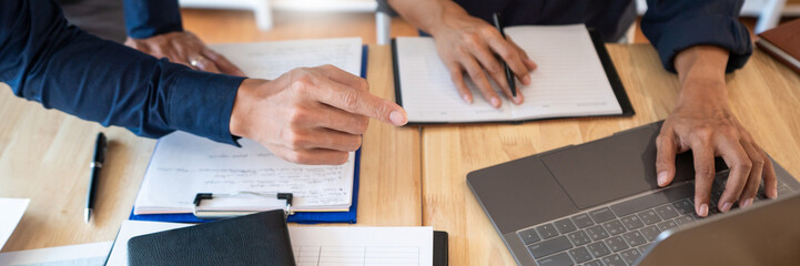 Young students classmates help friend catching up workbook and learning tutoring in a library, education and school concept